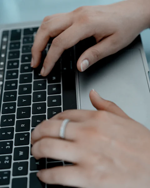 Des mains sur le clavier et le pavé tactile d'un ordinateur portable
